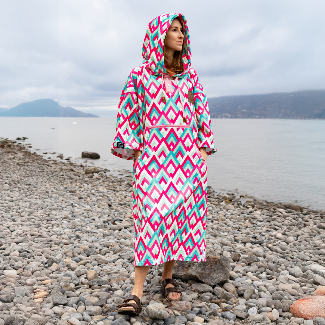 full body photo of women in outdoor changing poncho on beach